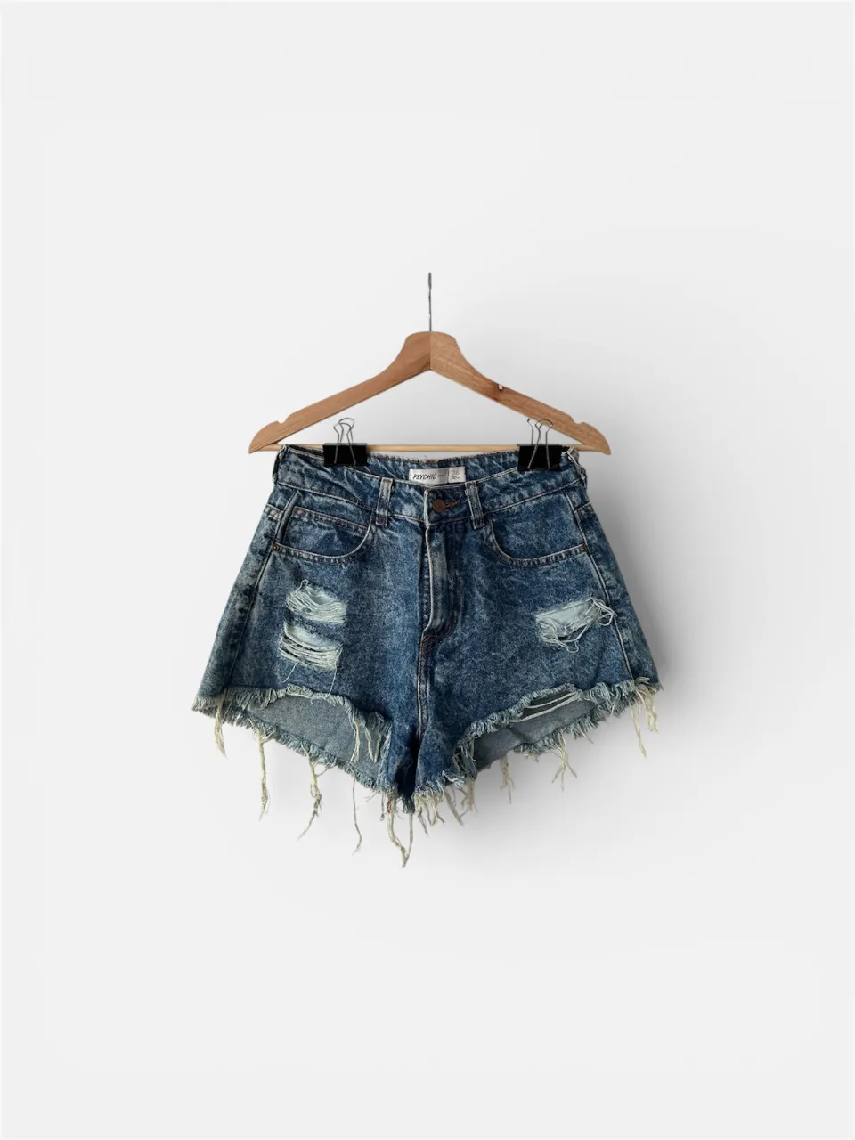 Shorts de jean tiro alto con roturas y detalles desflecados en los bordes. Lavado desgastado tipo 'acid wash' que le da un toque canchero y moderno. Ideales para un look relajado y con onda.