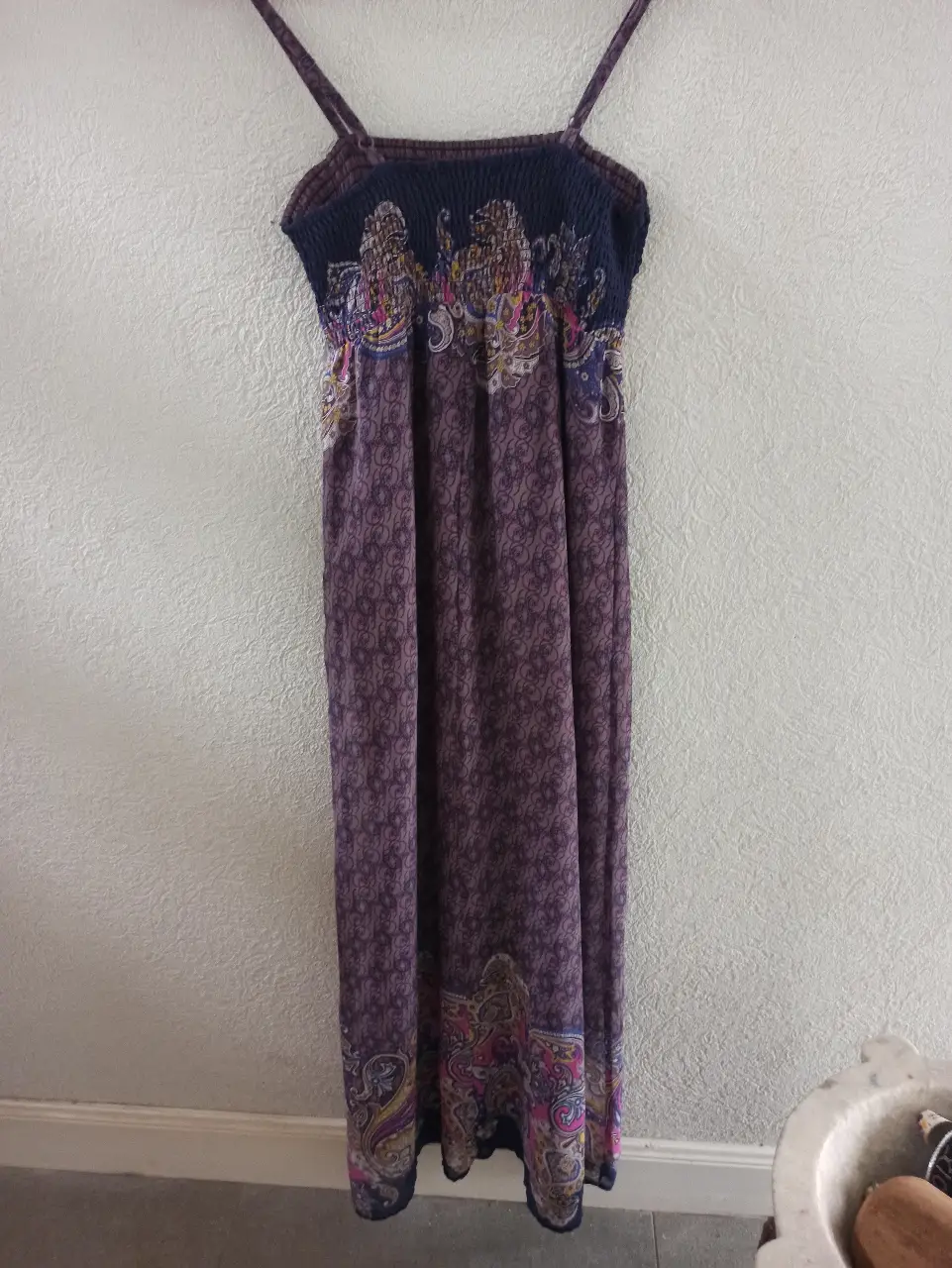 Vestido largo de verano con tirantes finos y estampado floral en tonos violetas y detalles en rosa y amarillo. Ideal para un look bohemio y fresco.
