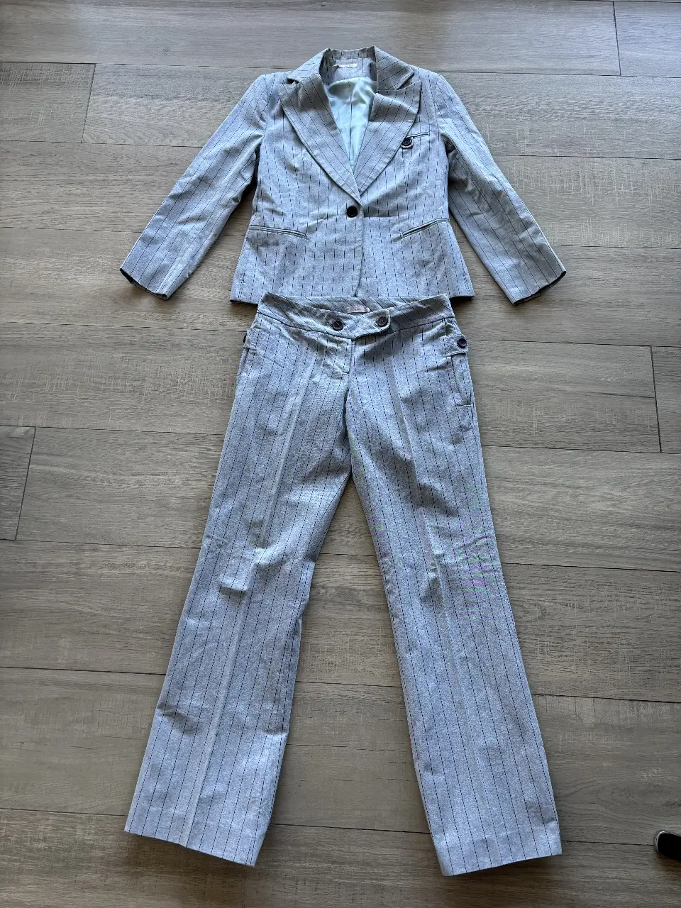 Traje de dos piezas para mujer, con pantalón sastrero a rayas y blazer a juego. Ideal para un look formal y elegante.
