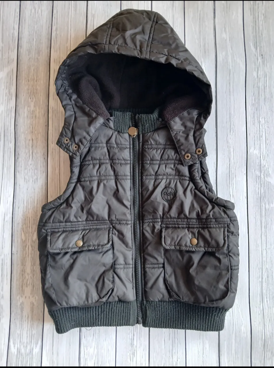 Chaleco acolchado con capucha para niño. por dentro polar.Posee dos bolsillos delanteros con botones y cierre frontal. Ideal para el invierno.
Medidas: 
sisa 39 cm
42 cm largo
prenda sin detalles