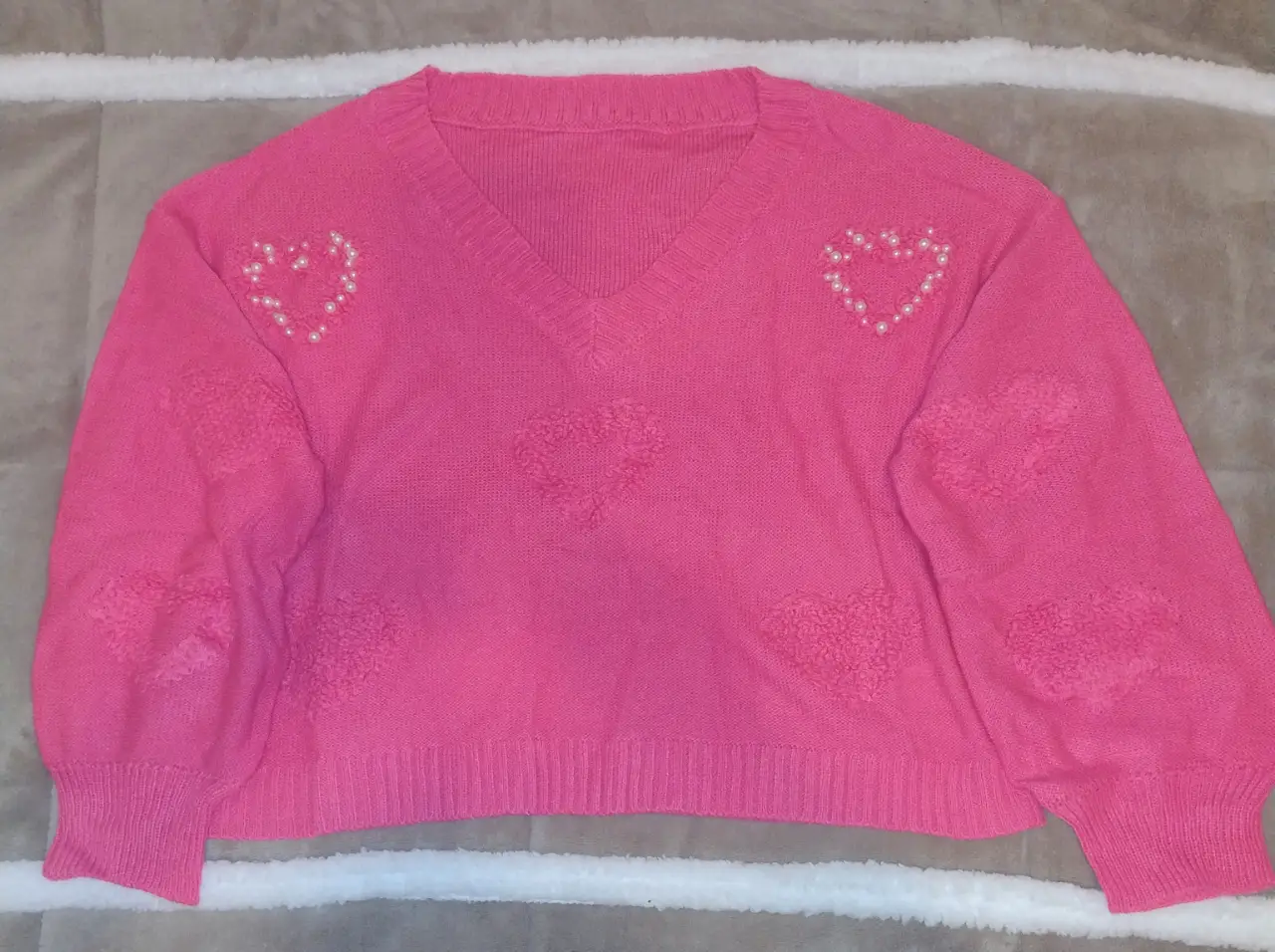 Sweater rosa oversize con diseño de corazones en relieve y detalles de perlas. Hombro:62 CM Largo:52 cm Largo de manga:47 CM Busto: 120