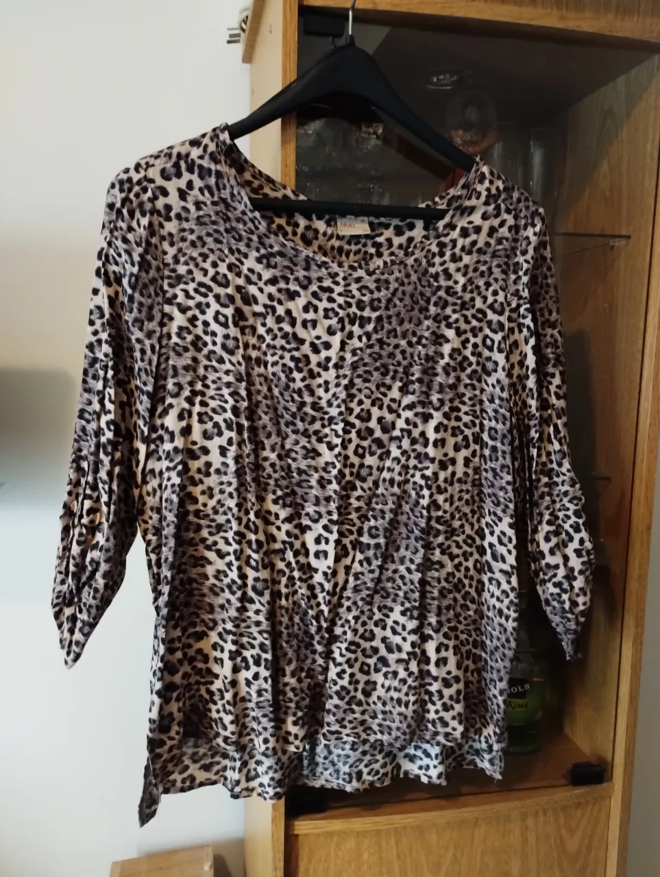 Blusa de mujer con estampado de leopardo, manga 3/4 y cuello bote. Ideal para un look casual y moderno.