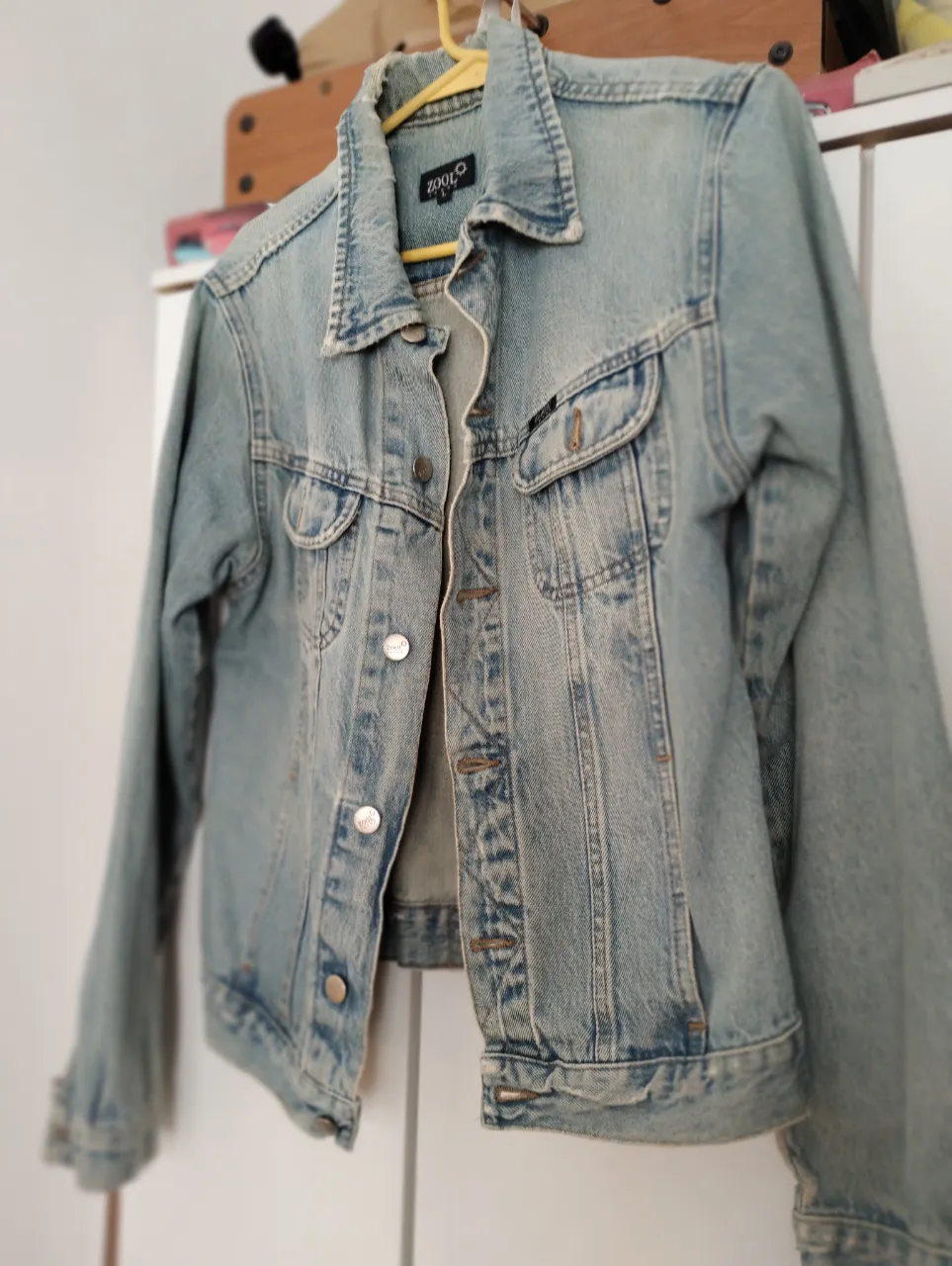 Campera de jean azul claro, estilo clásico, con bolsillos y botones metálicos. Ideal para un look casual y versátil.