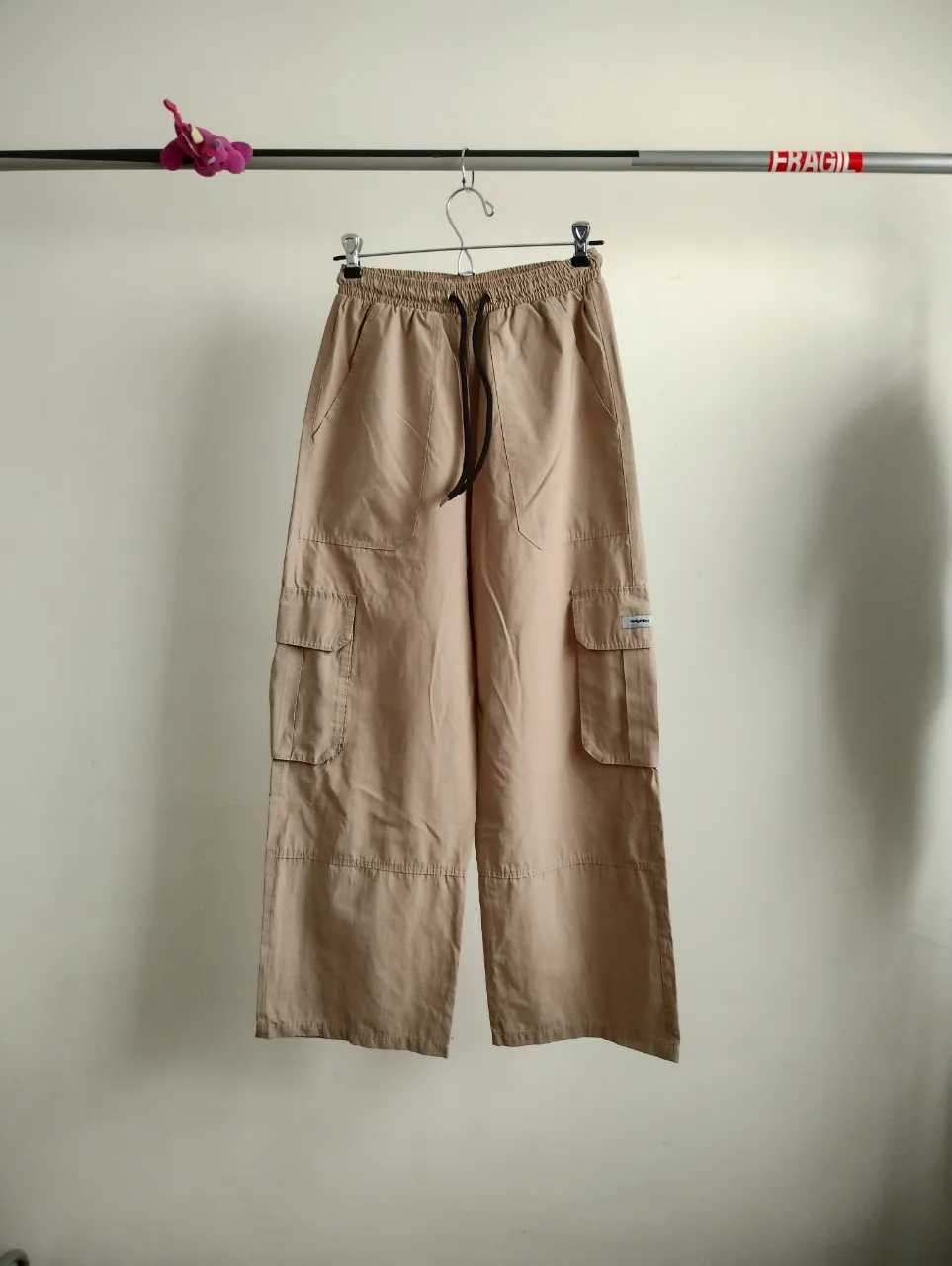 Pantalón cargo ancho, color beige, tiro alto con cintura elastizada y cordón. Posee bolsillos cargo a los costados y bolsillos frontales. Ideal para un look casual y cómodo. nuevo. va hasta talle 28