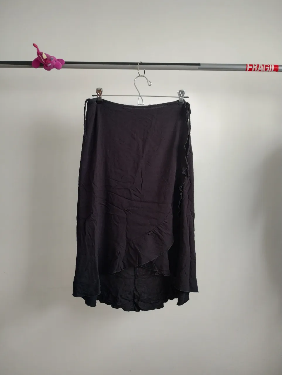 Pollera larga negra, estilo envolvente con detalle de volados en el borde. elastiza un poco. queda irregular. 