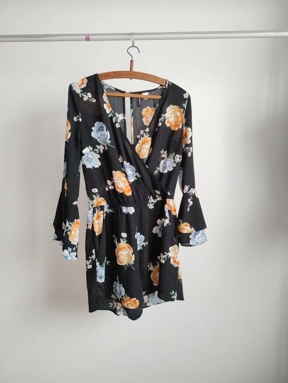 Mono largo de mujer, negro con estampado floral en tonos naranja y azul. Escote en V, mangas largas con volados y cintura elastizada. Ideal para un look fresco y con estilo.
tela tipo crep o gasa opaca.
 cintura: 36 a 40, largo 79 cm