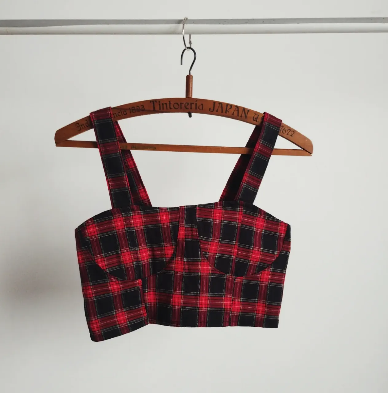 Top crop con estampado a cuadros en rojo y negro. Diseño con tirantes anchos y detalle de fruncido en la parte trasera. Ideal para un look moderno y audaz. hasta 90 de busto. 