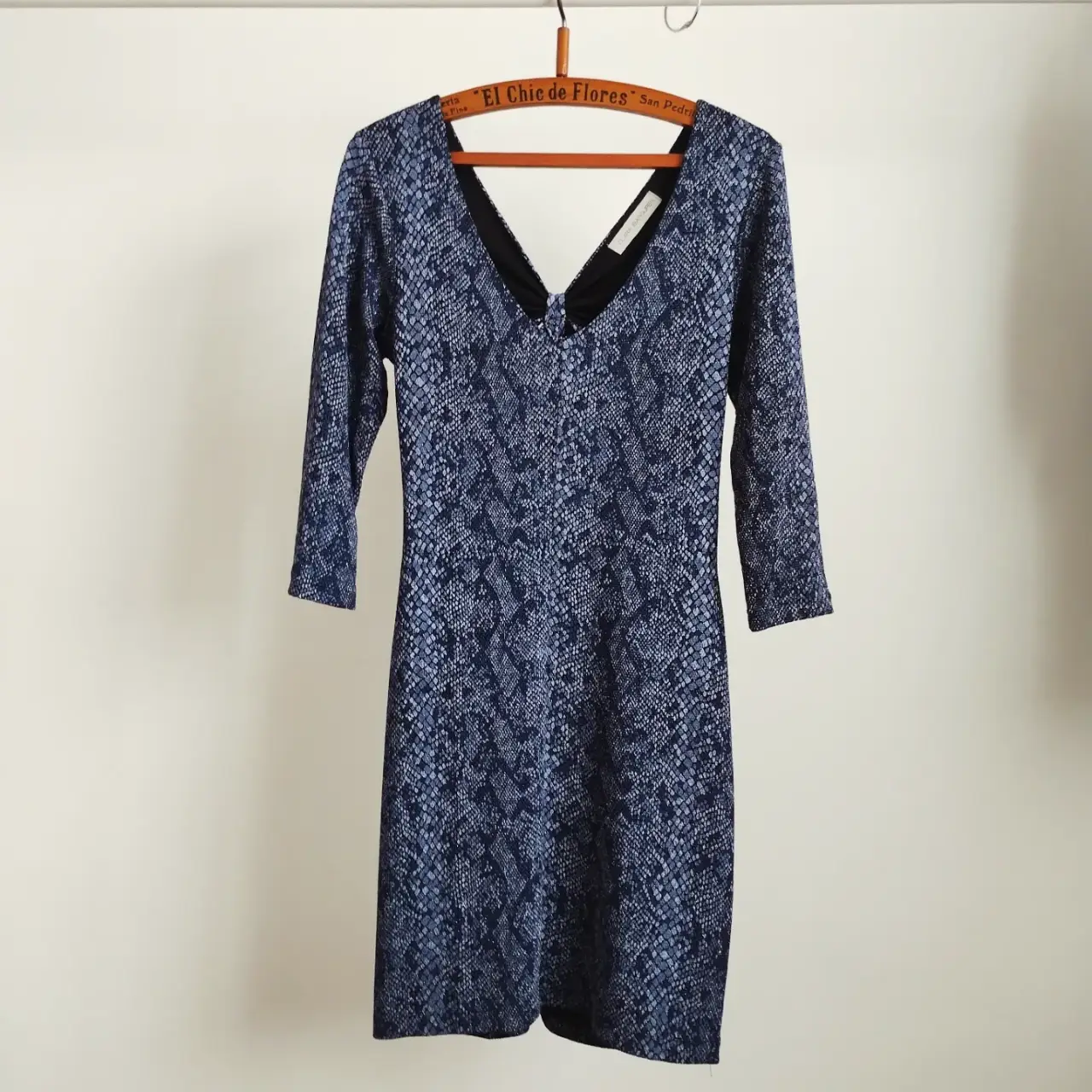Vestido corto de mujer (por encima de las rodillas), elastizado, con forro, con estampado de serpiente en tonos azules y negros, con brillo y textura. Tiene mangas 3/4 y un escote en V con detalle cut-out en la espalda. Ideal para una salida o fiesta. Cómo nuevo 