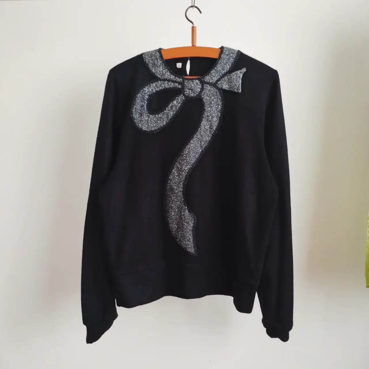 Sweater negro con aplique de moño plateado. Ideal para un look elegante y vintage. talle M/L