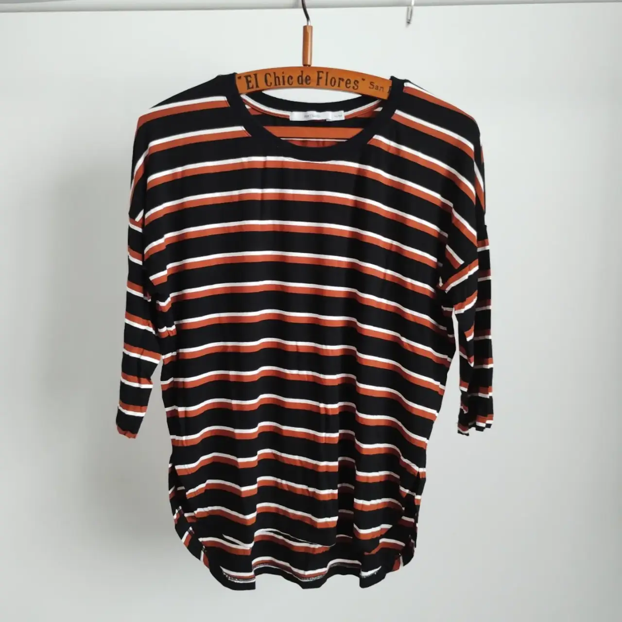Remera a rayas horizontales en negro, blanco y marrón. Manga 3/4, ideal para un look casual y cómodo. Talle 42/SM.