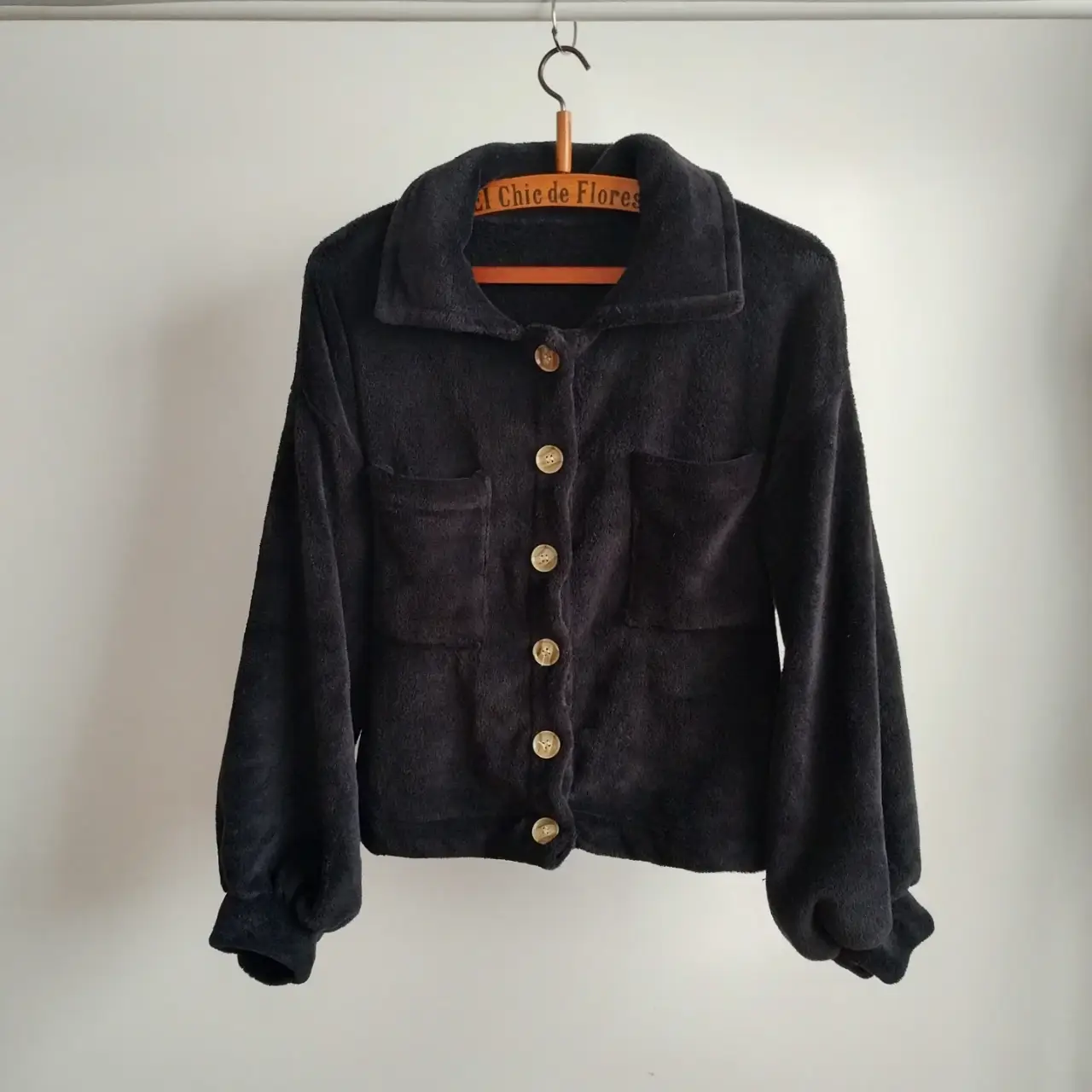 Campera negra de tela tipo peluche, con botones  y bolsillos. Ideal para un look cómodo y canchero. talle L/M