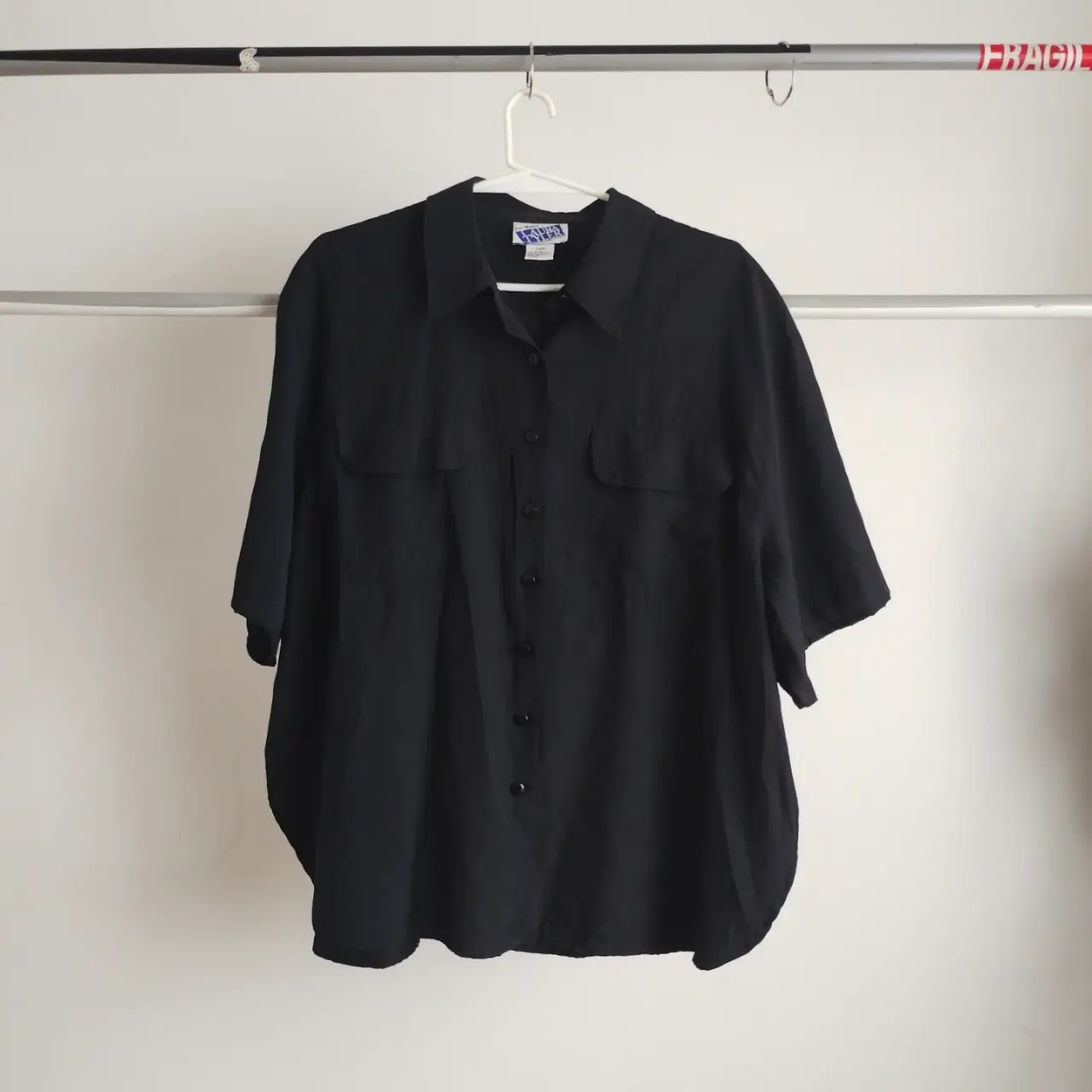 camisa negra de manga corta con dos bolsillos delanteros. ideal para un look casual y cómodo. vintage. amplia, impecable y de linda calidad. puede llegar a un XL