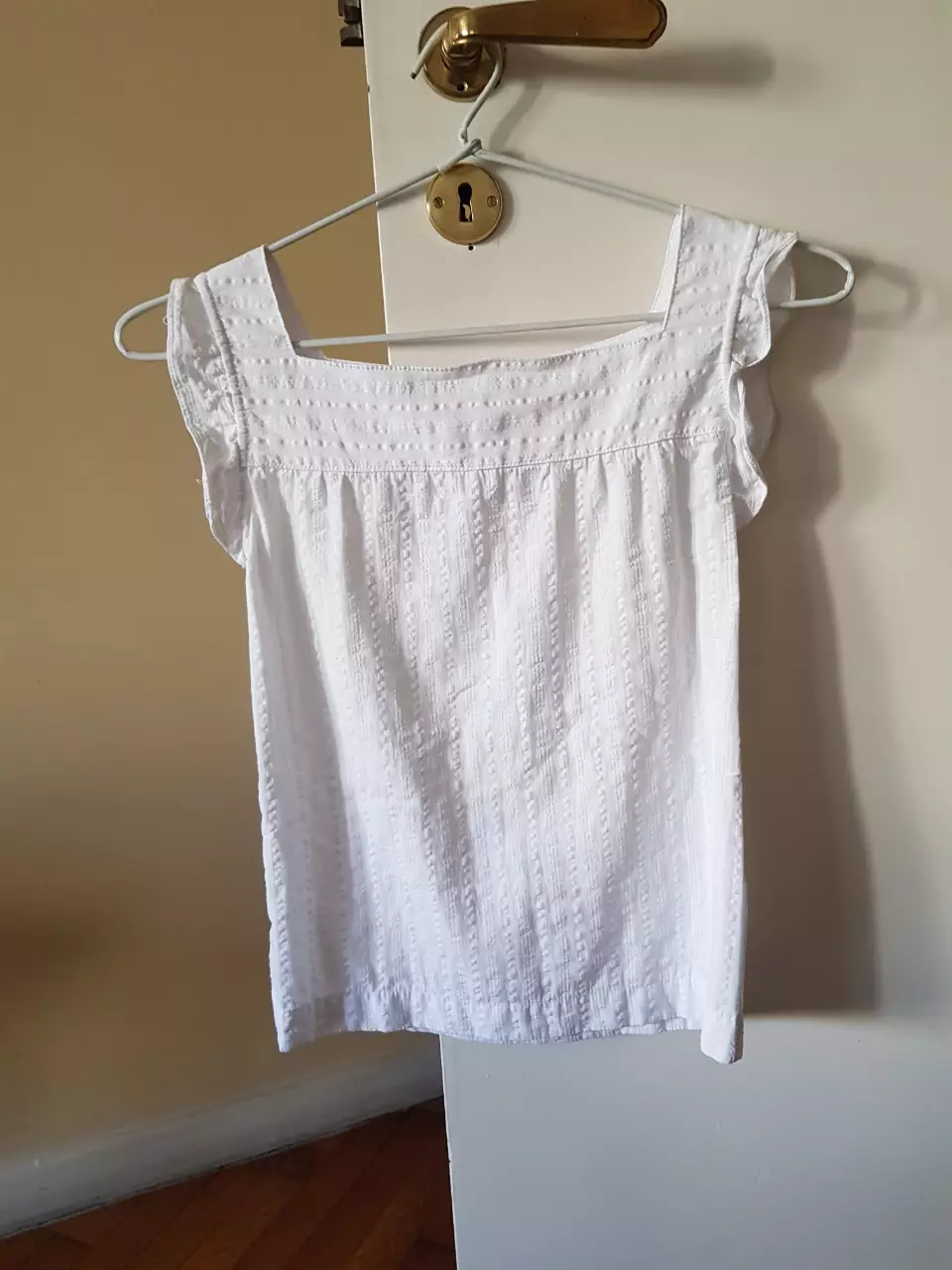 Blusa blanca con detalles bordados y mangas cortas con volados. Talle 10.