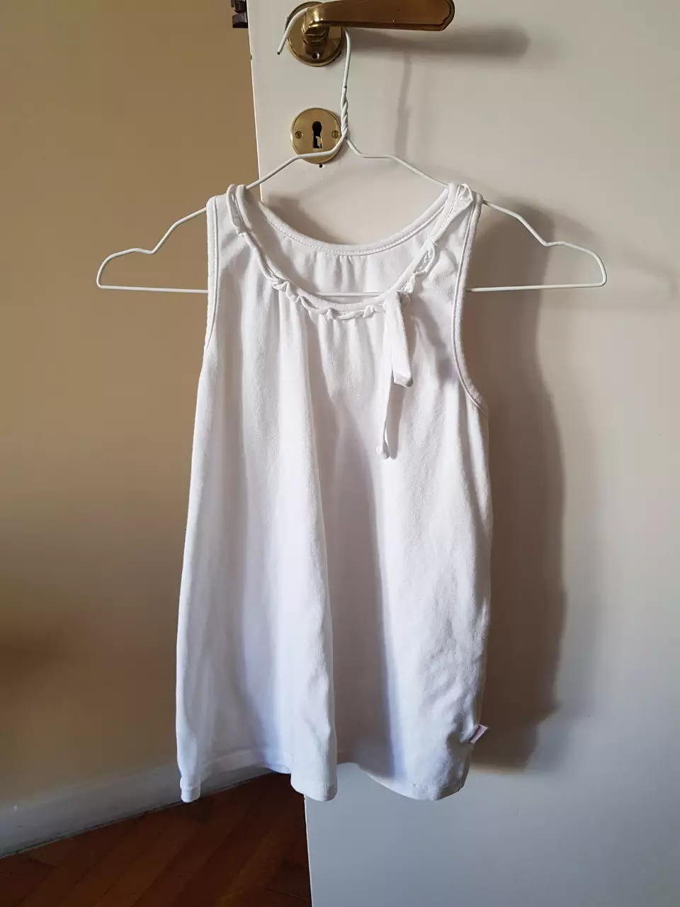 Musculosa blanca de niña, con detalle de volado en el cuello. Ideal para el verano.