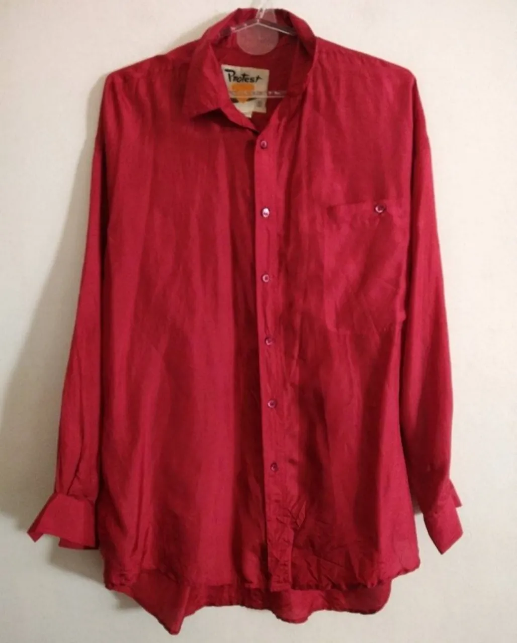 Camisa importada de seda, color ciruela de manga larga, con botones al frente y un bolsillo en el pecho. Un clásico que no puede faltar en tu guardarropa. Hermosa!! Creo que básicamente es de hombre porque talle s es bastante grande y suelto aunque pueda ser unisex.. preguntar medidas ante la duda.