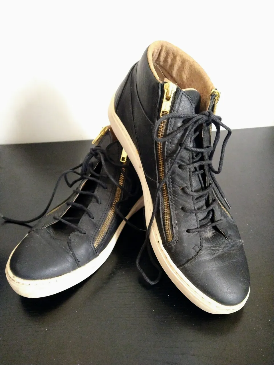 Zapatillas urbanas de cuero negro, con cordones y cierre lateral dorado. Ideales para un look casual y moderno. Sin caja original.