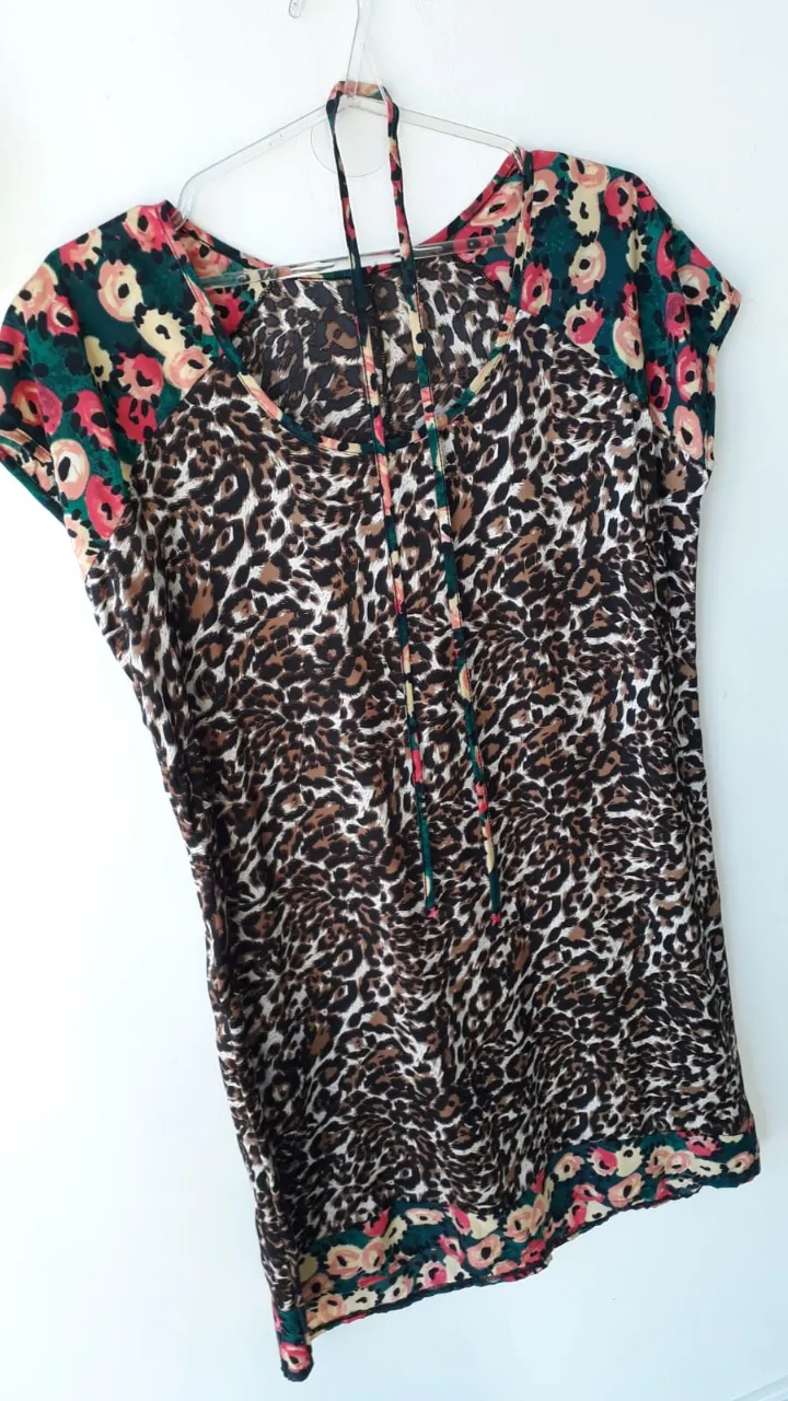 Vestido estampada con motivo de leopardo y detalles florales en los hombros y el borde inferior. Posee un escote en V con tiras para atar en la cintura. Ideal para un look casual y canchero. Súper fresco. Nuevo, sin uso. Es divino!!