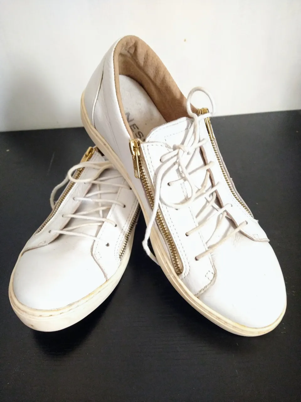 Zapatillas blancas de cuero con cordones y cierre lateral. Ideales para un look casual y cómodo. Sin caja original.
