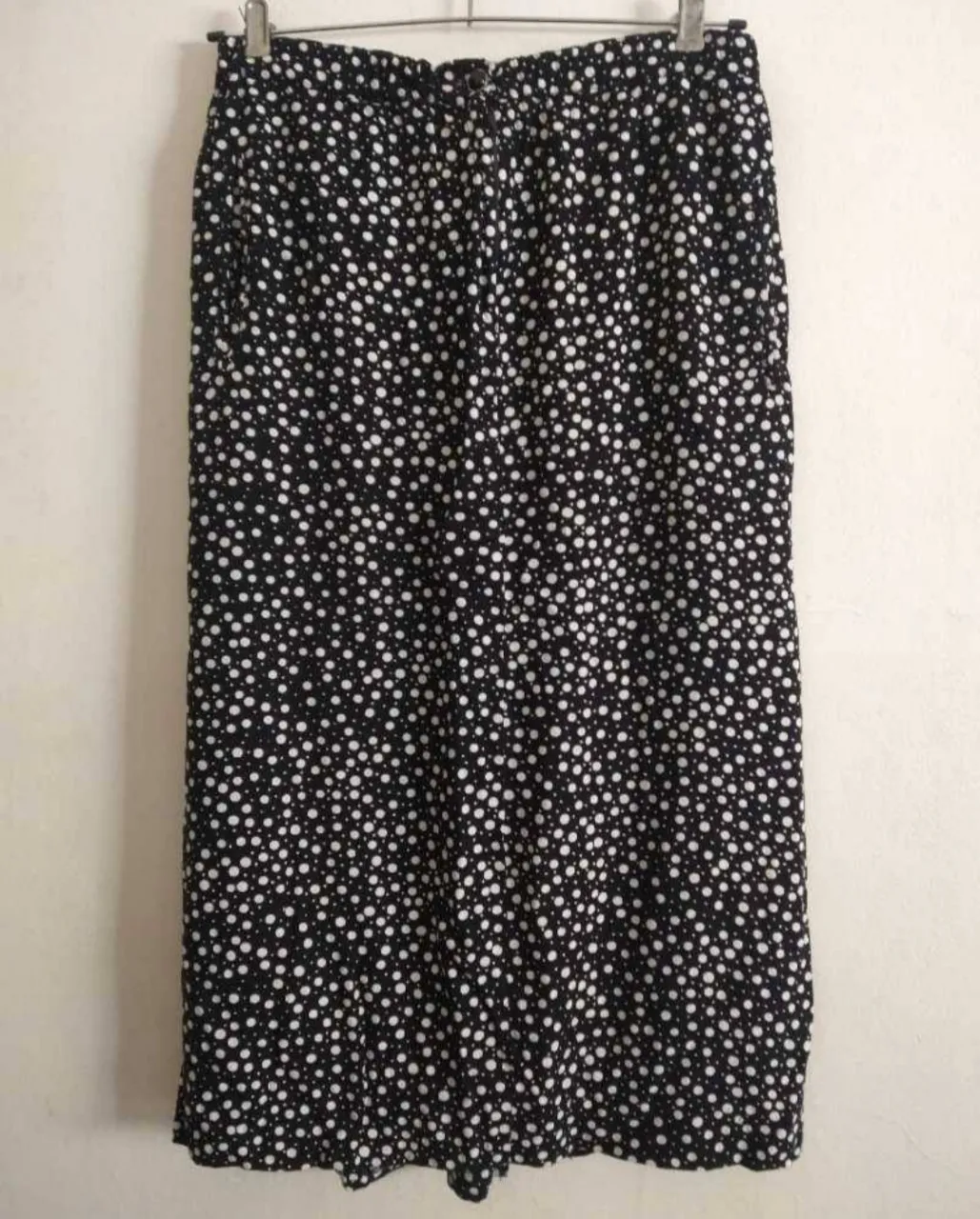 Pollera negra c lunares blancos, cintura elastizada! más boton para abrochar y cierre. bolsillos laterales y uno pequeño atrás. Tajo atrás. La etiqueta dice M, es amplia. medidas: cintura (sin estirar) 40cm y estira 10cm más! ancho 54cm, abajo 60cm más tajo de 25cm, largo total 80cm. Está descosido el dobladillo. Está arrugada de estar guardada!.