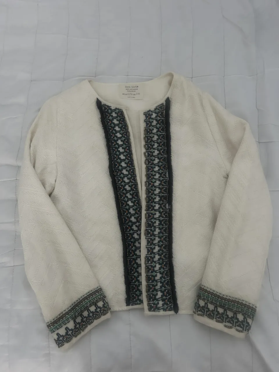 Chaqueta blanca con bordados étnicos en cuello y puños. Ideal para un look boho chic.