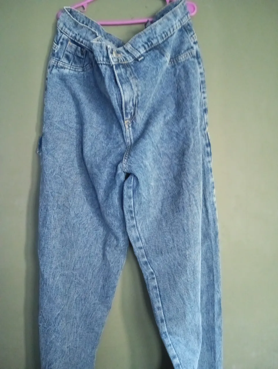 Jeans de algodón color celeste con lavado desgastado. Poseen bolsillos delanteros y traseros, y un bolsillo adicional con tapa en el lateral izquierdo. Cierre y botón en la parte delantera. Talle 44.