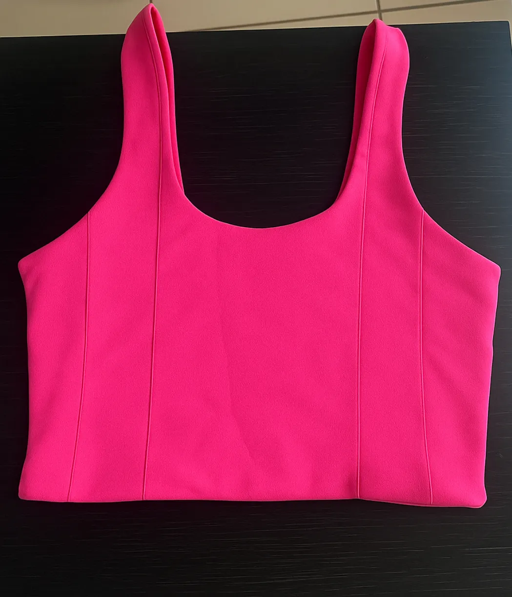 Top deportivo fucsia con breteles anchos y escote cuadrado. Ideal para entrenar o para un look casual y moderno.