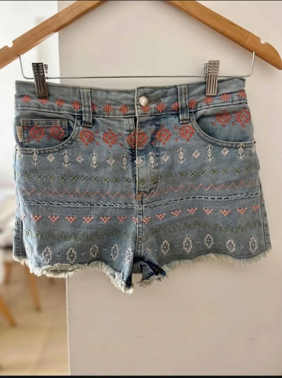 Short de jean de mujer con bordados artesanales en tonos rosados y blancos. Diseño tiro medio con detalles desflecados en el borde inferior. Ideal para un look boho chic.

La prenda esta arrugada por estar guardada, pero se entrega planchada 😊