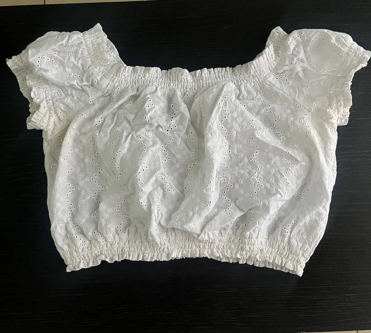 Blusa crop de mujer, blanca, con detalles calados y mangas cortas. Ideal para un look fresco y casual. d

