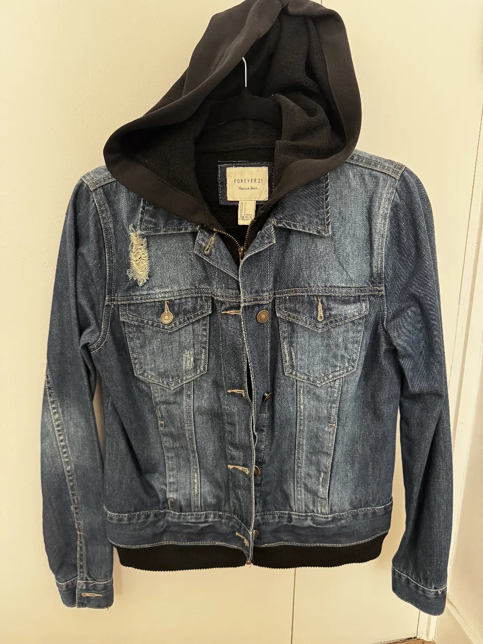 Campera de jean azul con capucha negra desmontable. Estilo casual, ideal para un look urbano y moderno. Marca Forever 21, talle S.