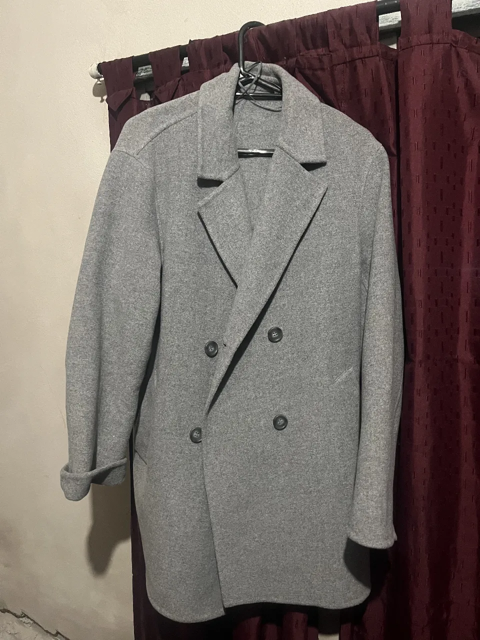 Tapado gris de paño, con doble botonadura y solapas clásicas. UNIQLO