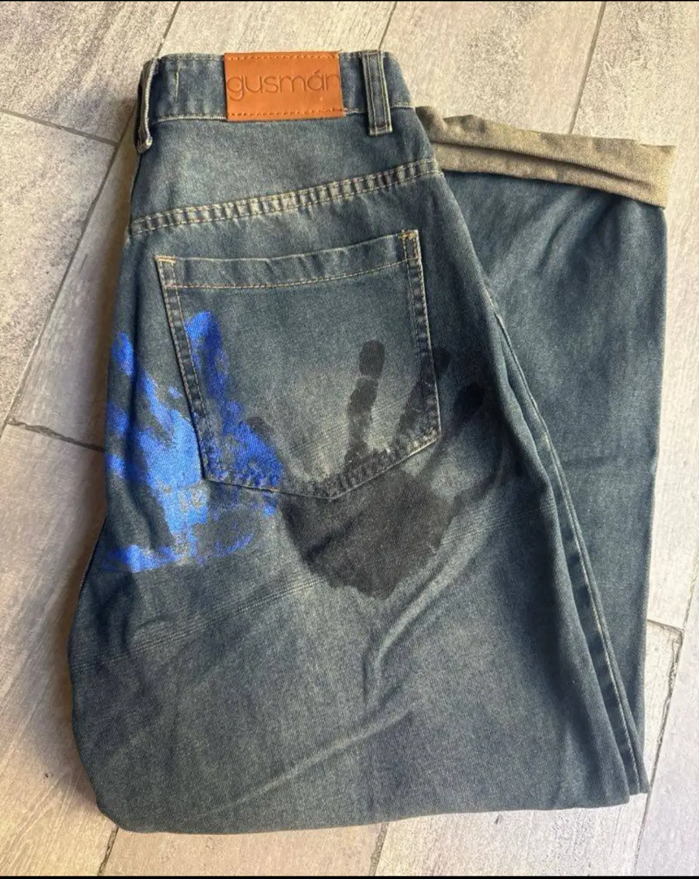 Jeans Gusman talle 27/28 con detalles de manos pintadas en azul y negro. Tiro medio, corte mom. Ideal para un look urbano y canchero.lo vendo porque me quedó grande! es cancherisimo