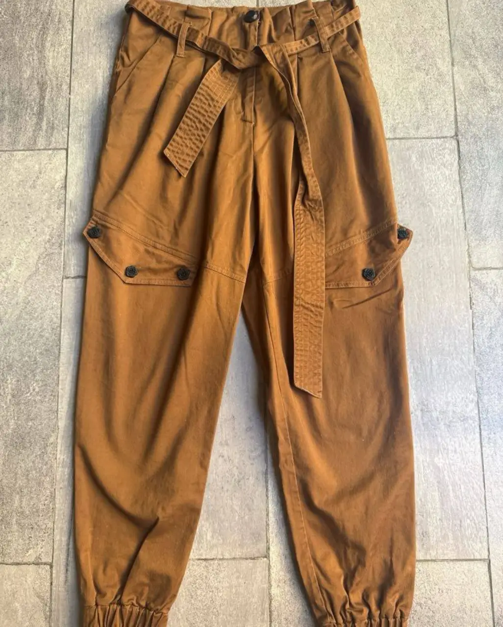 Pantalón cargo/babucha marca Fini Braun marrón con cinturón, bolsillos laterales con botones y ajuste en los tobillos. Talle M.va para un 26