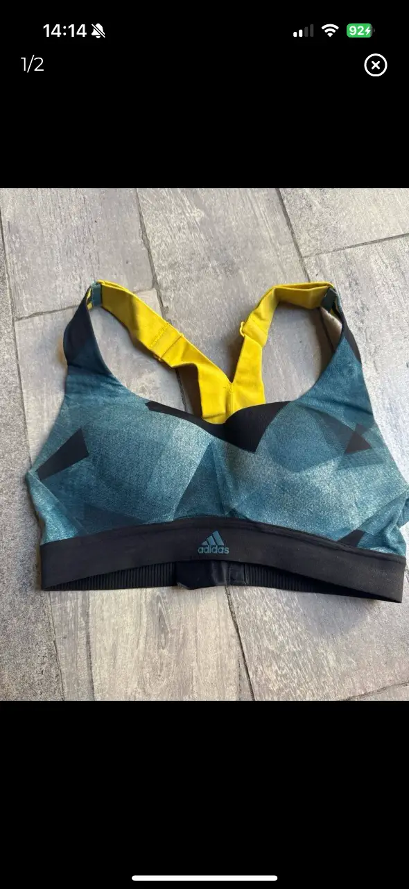 Top deportivo Adidas, con diseño geométrico en tonos azul y negro, con detalles en amarillo en las tiras y borde inferior. Ideal para actividades de alto impacto. va para un 85 de busto 