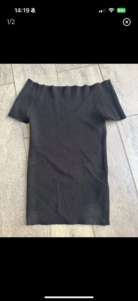 Top negro de tejido de punto con cuello barco y mangas cortas. Ideal para un look casual y moderno. medidas largo total 41. ancho 25 ( tener en cuenta que la tela se estira mucho) 