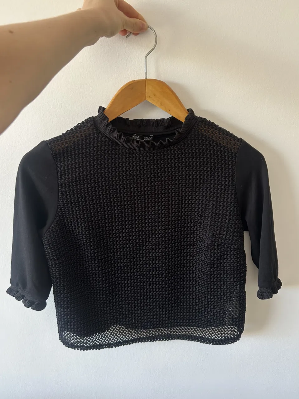 Remera negra Zara Portugal, de manga 3/4 con cuello y puños con volados. El frente es de red con un tejido texturizado y la parte de atrás es de tela opaca. 
Queda corta aprox altura del ombligo y el talle es bastante ajustado.