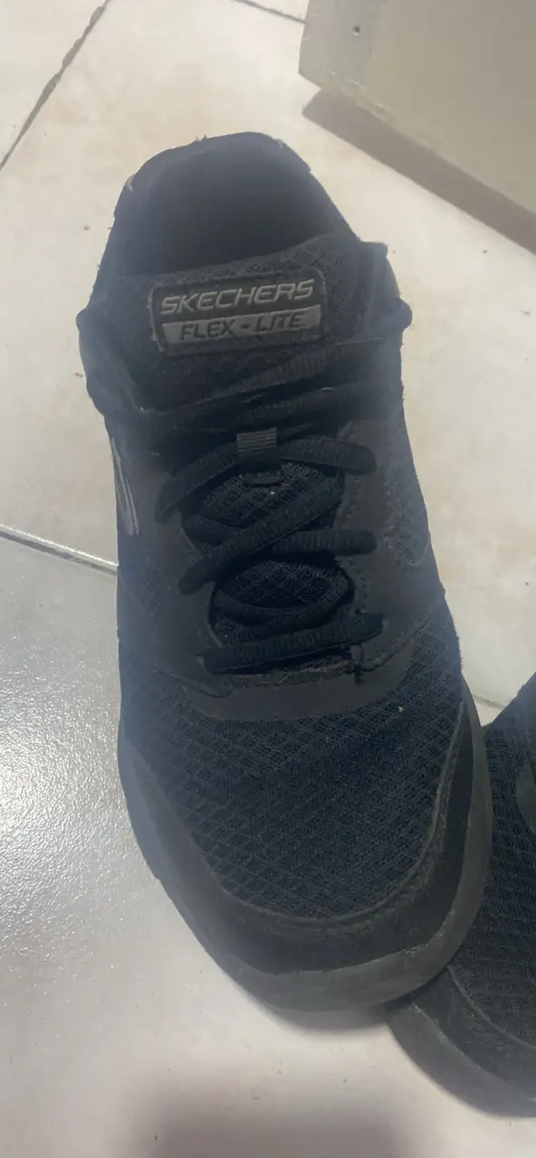 Zapatillas Skechers Flex Lite negras, ideales para running y uso diario. Diseño deportivo y cómodo.