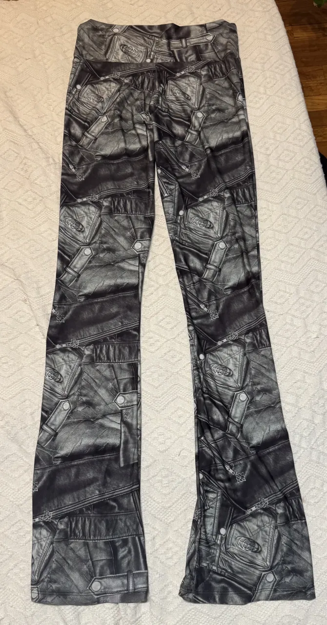 Calzas acampanadas estampados con diseño de cuero y como si tuviese múltiples bolsillos y cierres. Por detrás y delante es igual. Se puede usar tiro alto o tiro bajo bajándole de la cintura la tela 