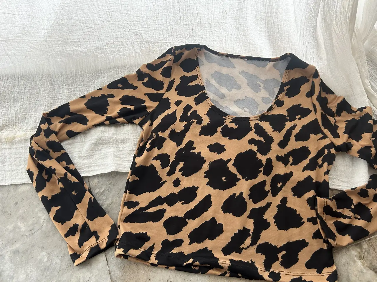 Remera de manga larga con estampado de leopardo en tonos marrones y negros. Ideal para un look audaz y moderno.