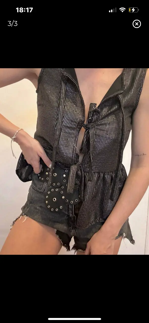 Chaleco  negro con detalles plateados, con lazos y volados. Ideal para un look de fiesta o salida.