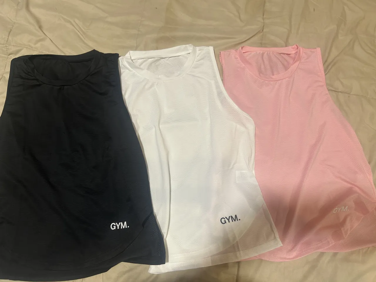 Musculosas deportivas de cuello redondo, sin mangas. Vienen en color negro, blanco y rosa. Tienen un logo pequeño en la parte inferior derecha.