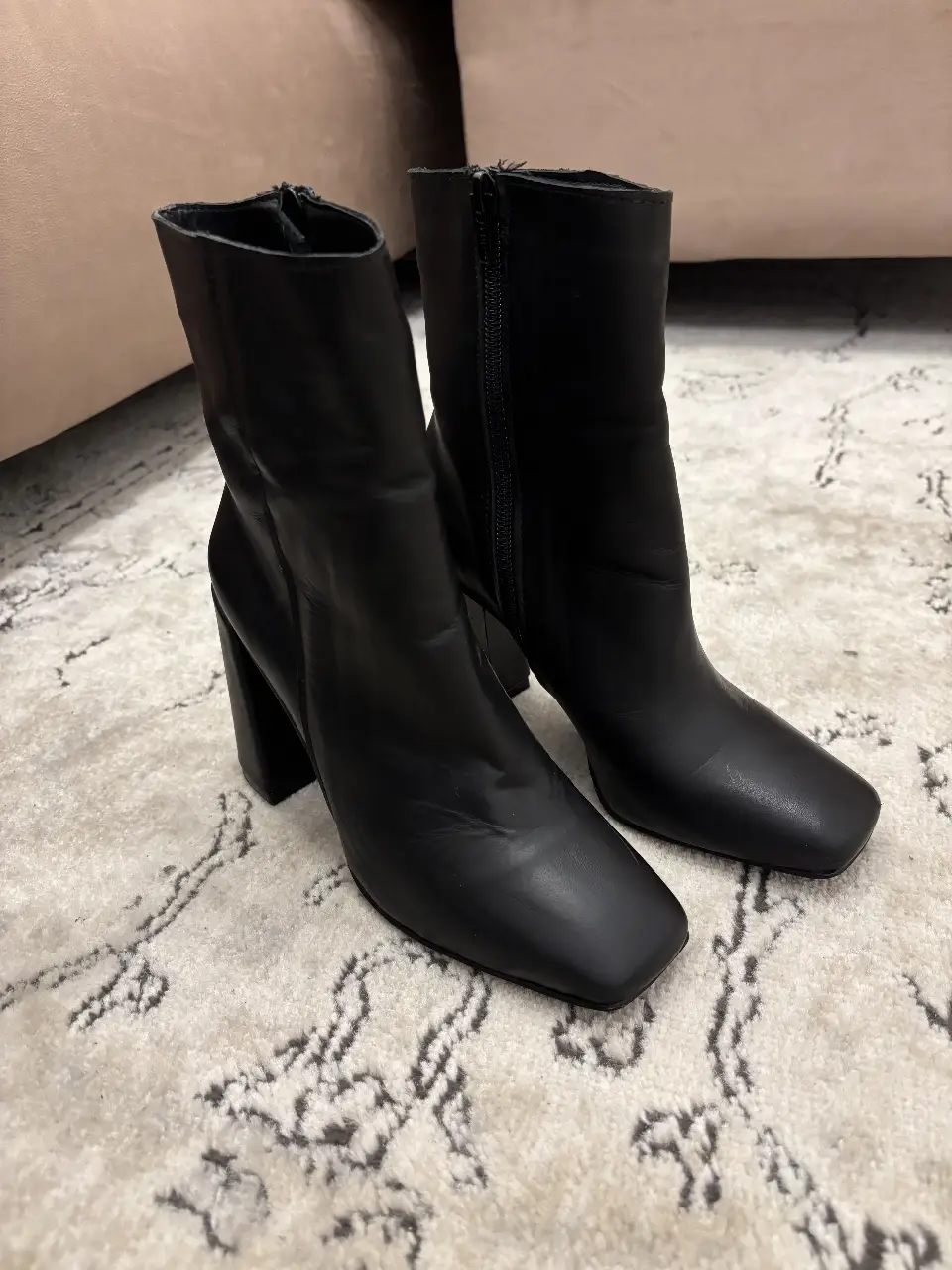 Botas negras de 100% cuero  con taco cuadrado y cierre lateral. Ideales para un look moderno y sofisticado.
