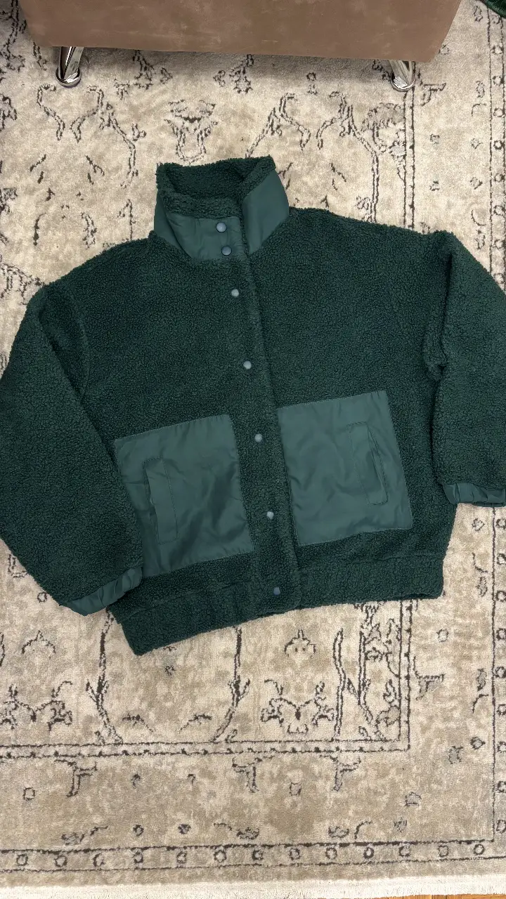 Campera de abrigo estilo teddy bear en color verde oscuro. Posee cuello alto y bolsillos delanteros. Ideal para un look casual y abrigado. medidas al final