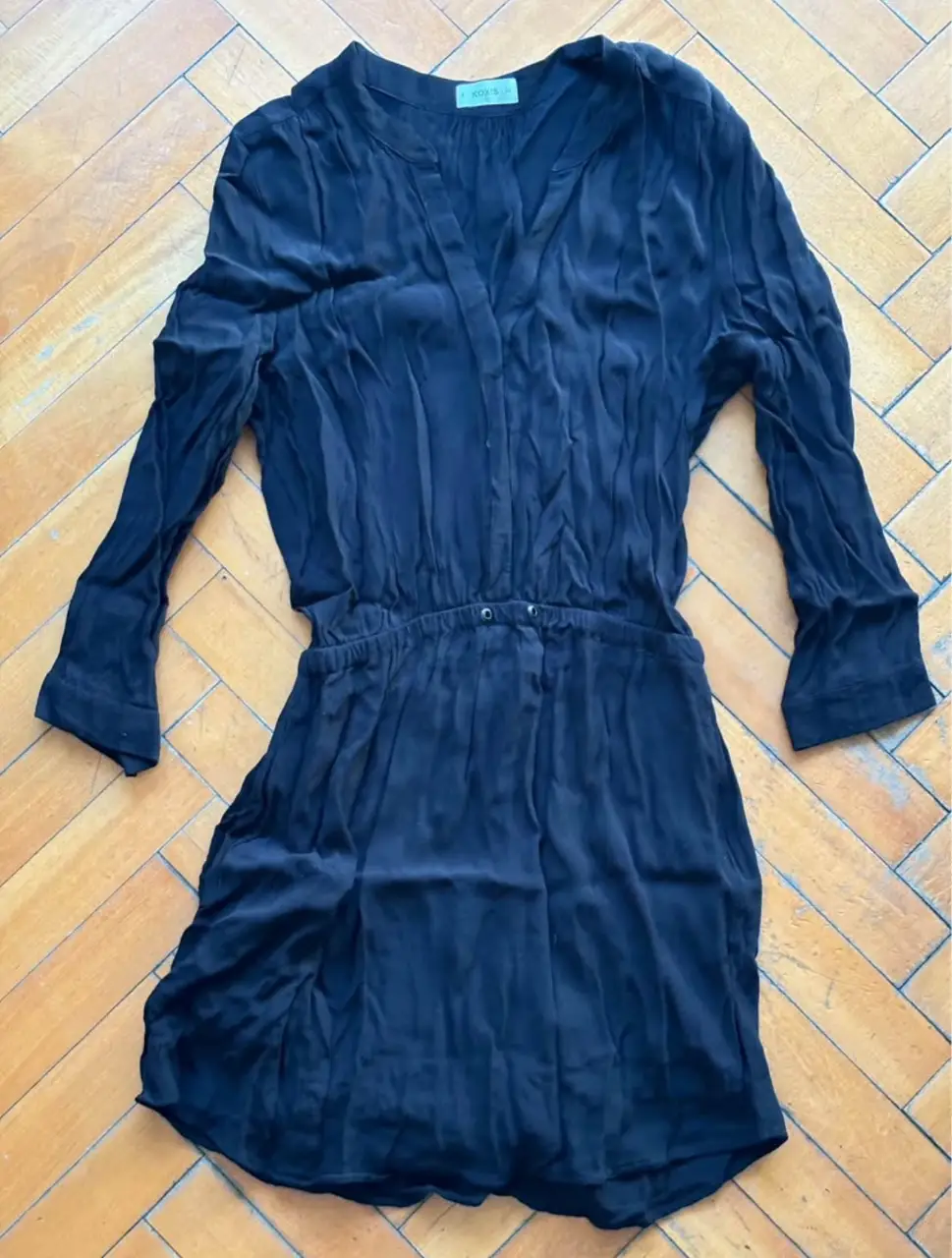 Vestido midi negro de seda, con escote en V y mangas largas. Ideal para una salida elegante o una ocasión especial.
