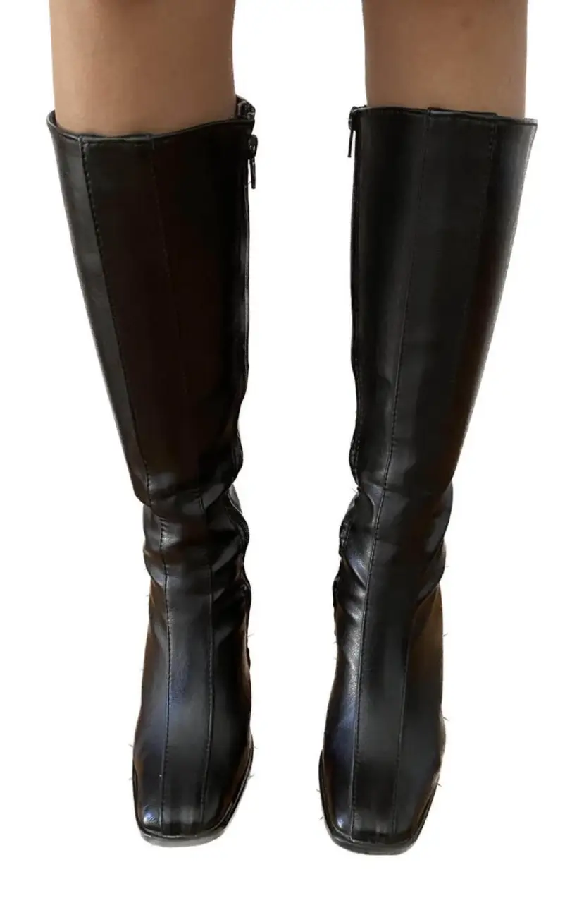 Botas de caña alta negras, ideales para un look elegante y moderno. Confeccionadas en cuero sintético de alta calidad, estas botas son perfectas para cualquier ocasión. Su diseño clásico y atemporal las convierte en un básico imprescindible en tu guardarropa.