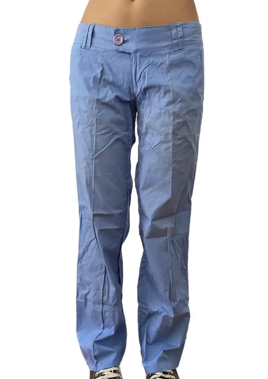 Pantalón sastrero de mujer, color celeste. Confeccionado en tela liviana, ideal para un look casual o de trabajo. Cuenta con un botón decorativo y bolsillos.