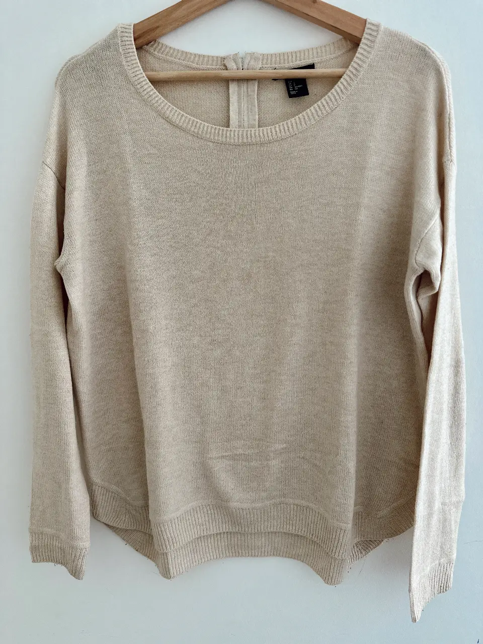 Sweater largo de punto en color crudo, ideal para un look casual y cómodo. Cuello redondo y detalle de cierre en la espalda.