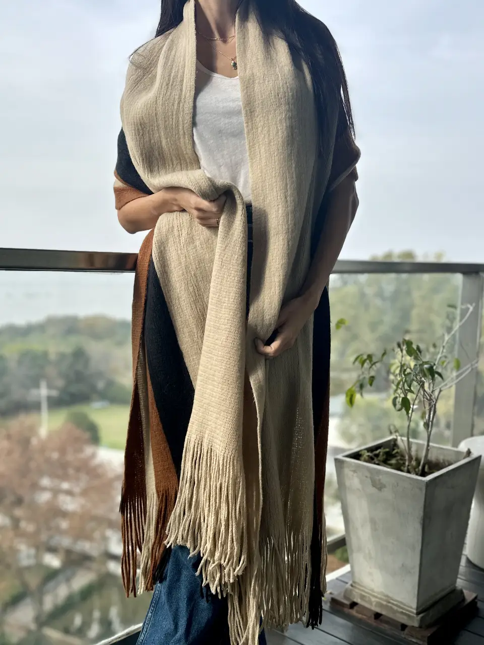Bufanda larga a rayas en tonos crudo, negro y marrón. Ideal para abrigarte con estilo en otoño e invierno. Un accesorio versátil y cómodo para cualquier ocasión.