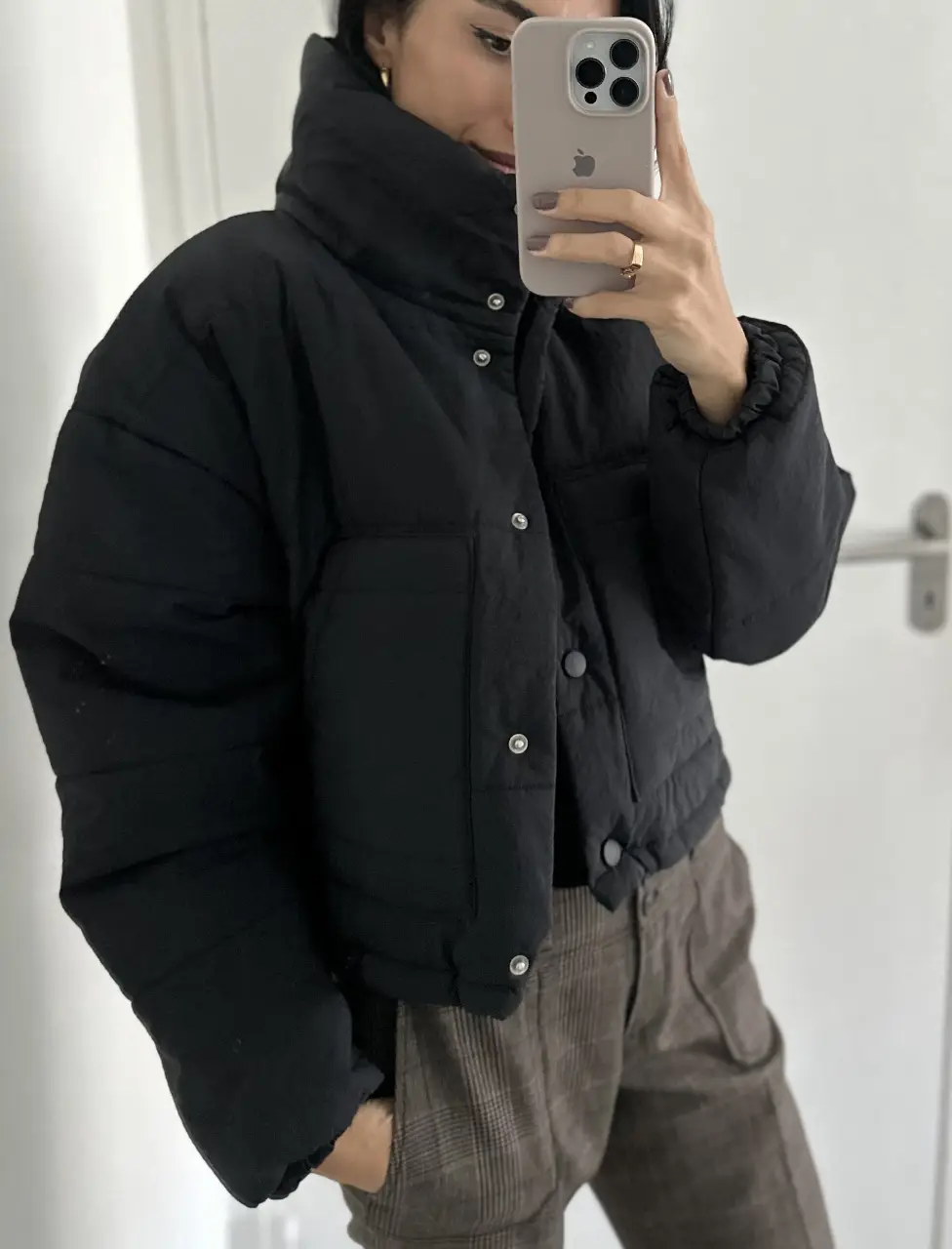 Campera puffer negra, ideal para el invierno. Cuello alto y cierre con botones. Bolsillos delanteros.