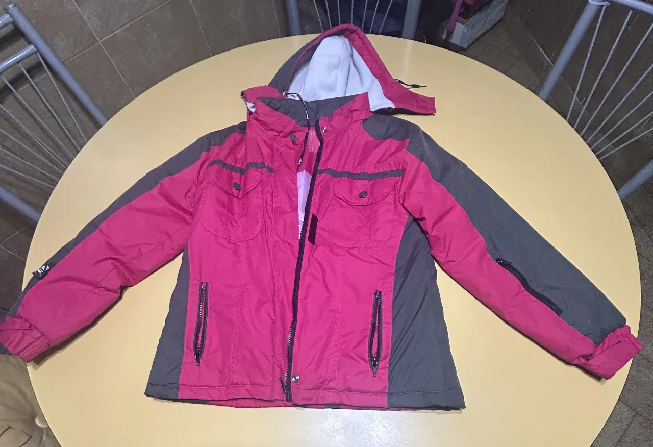 Campera deportiva para mujer, color rosa y gris. Con capucha y cierre frontal. Ideal para actividades al aire libre.