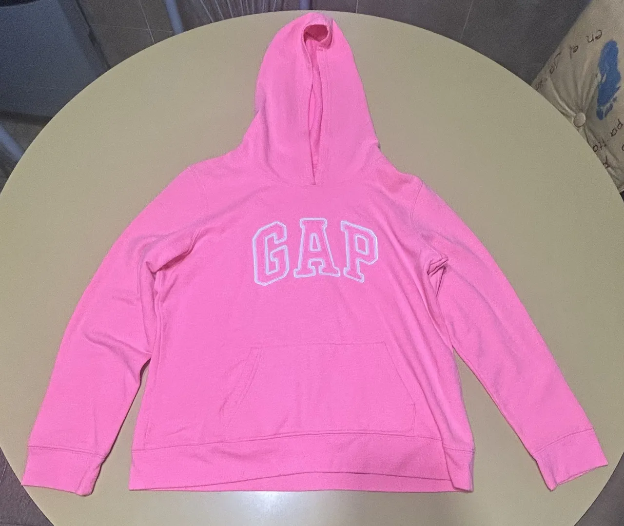 Buzo canguro rosa de la marca GAP, con capucha y bolsillo frontal. Ideal para un look casual y cómodo.